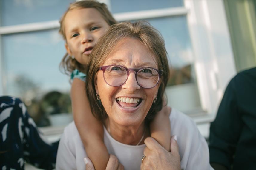 An older woman giving a young child a piggyback ride