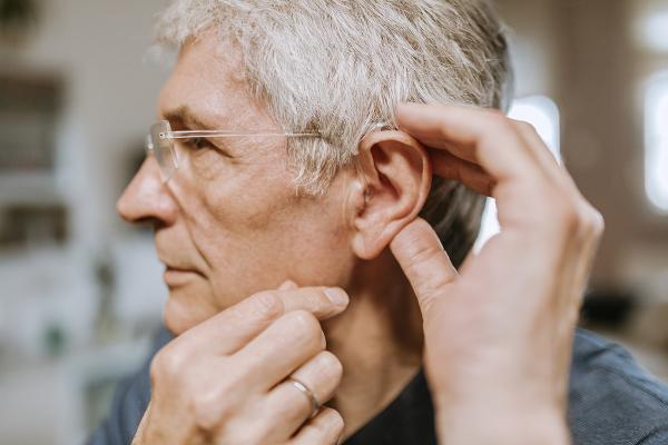 A man holding his ear open to the camera