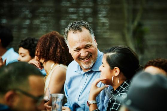 Man laughing in a social gathering setting